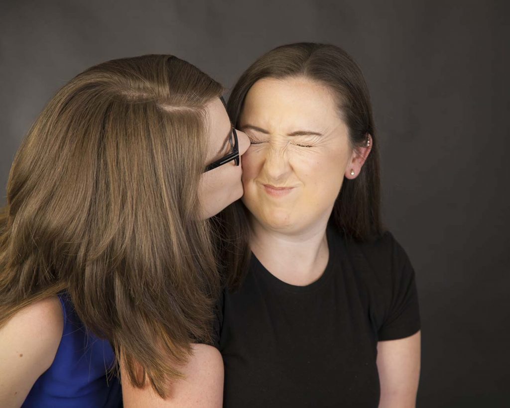 sister gives a kiss to an face